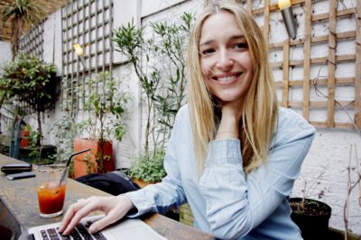 woman on computer outdoors creating website